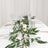 Elegant dining table setting with greenery and glassware.