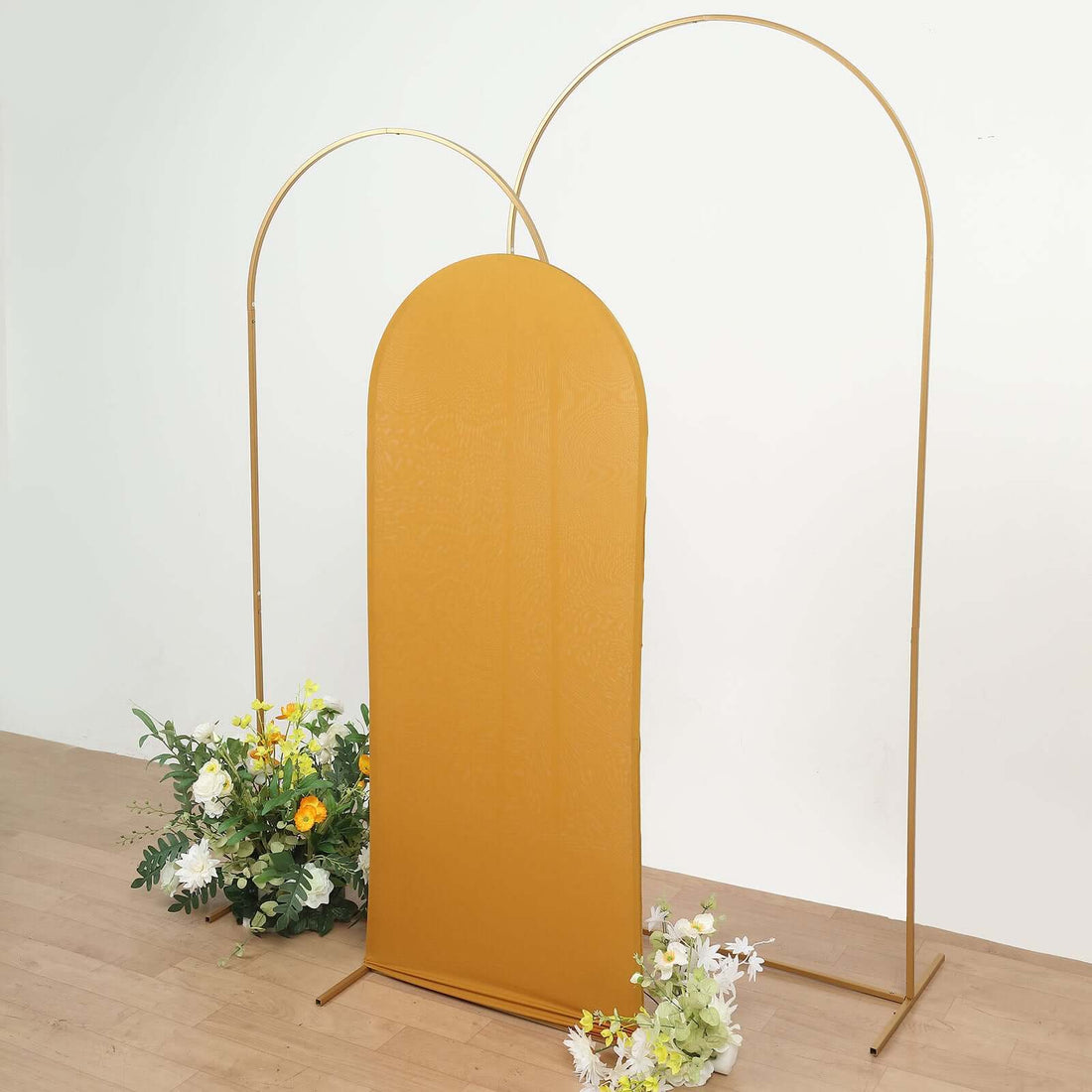 Gold arch backdrop with floral arrangements on either side.