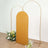 Gold arch backdrop with floral arrangements on either side.