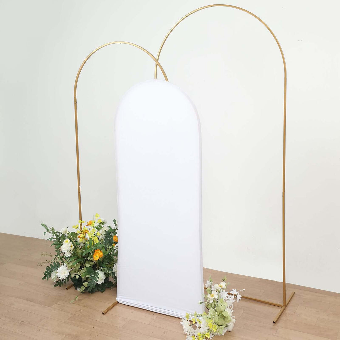 White backdrop with gold arch and floral arrangements