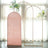 Pink backdrop with gold stand and floral arrangements in a bright, airy setting.
