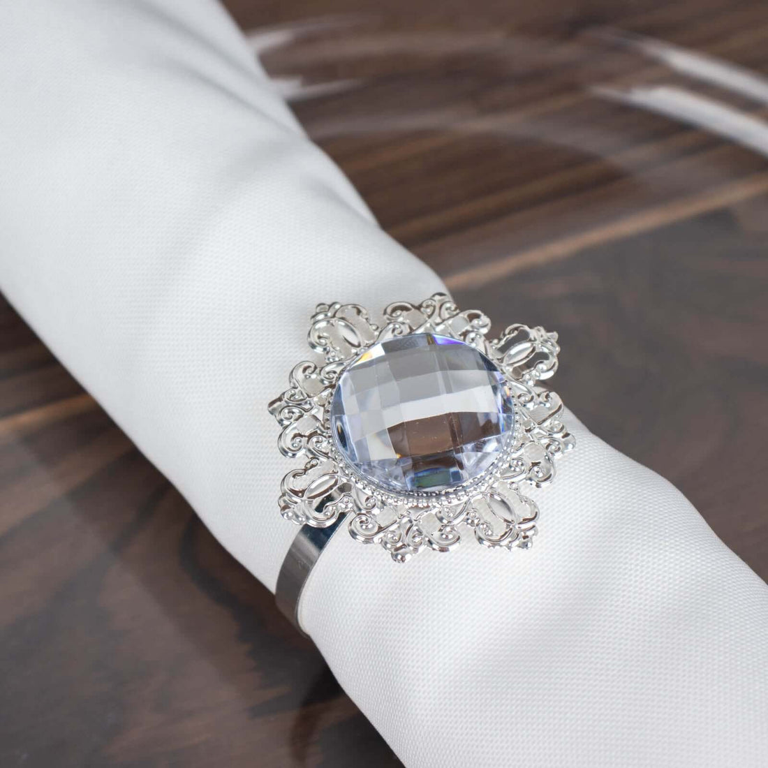 Elegant silver ring with a large crystal centerpiece on a napkin.