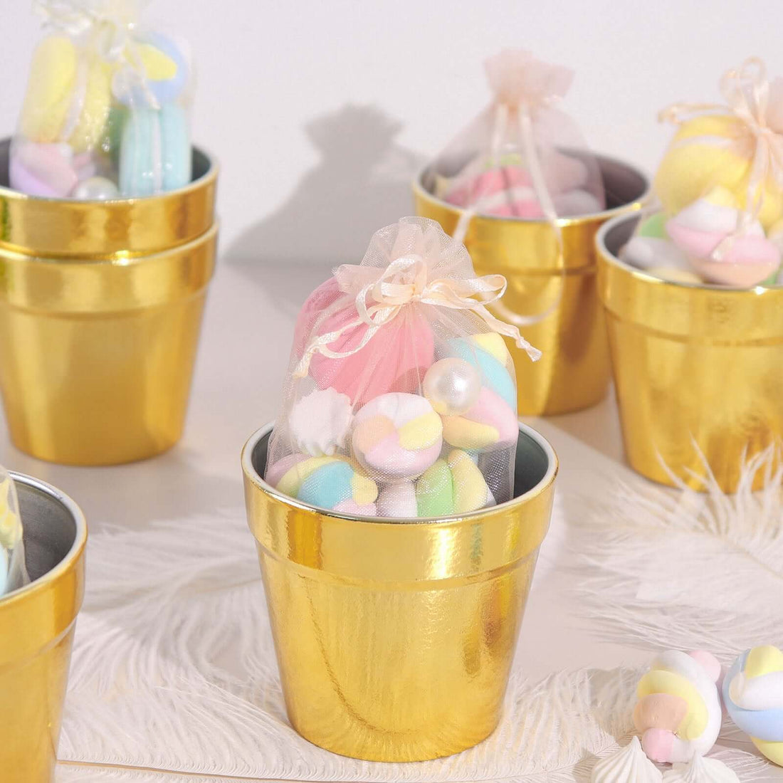 Gold pots filled with colorful bath bombs in sheer bags.