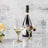 Elegant champagne glasses with cherries and a bottle of sparkling wine on a marble surface.