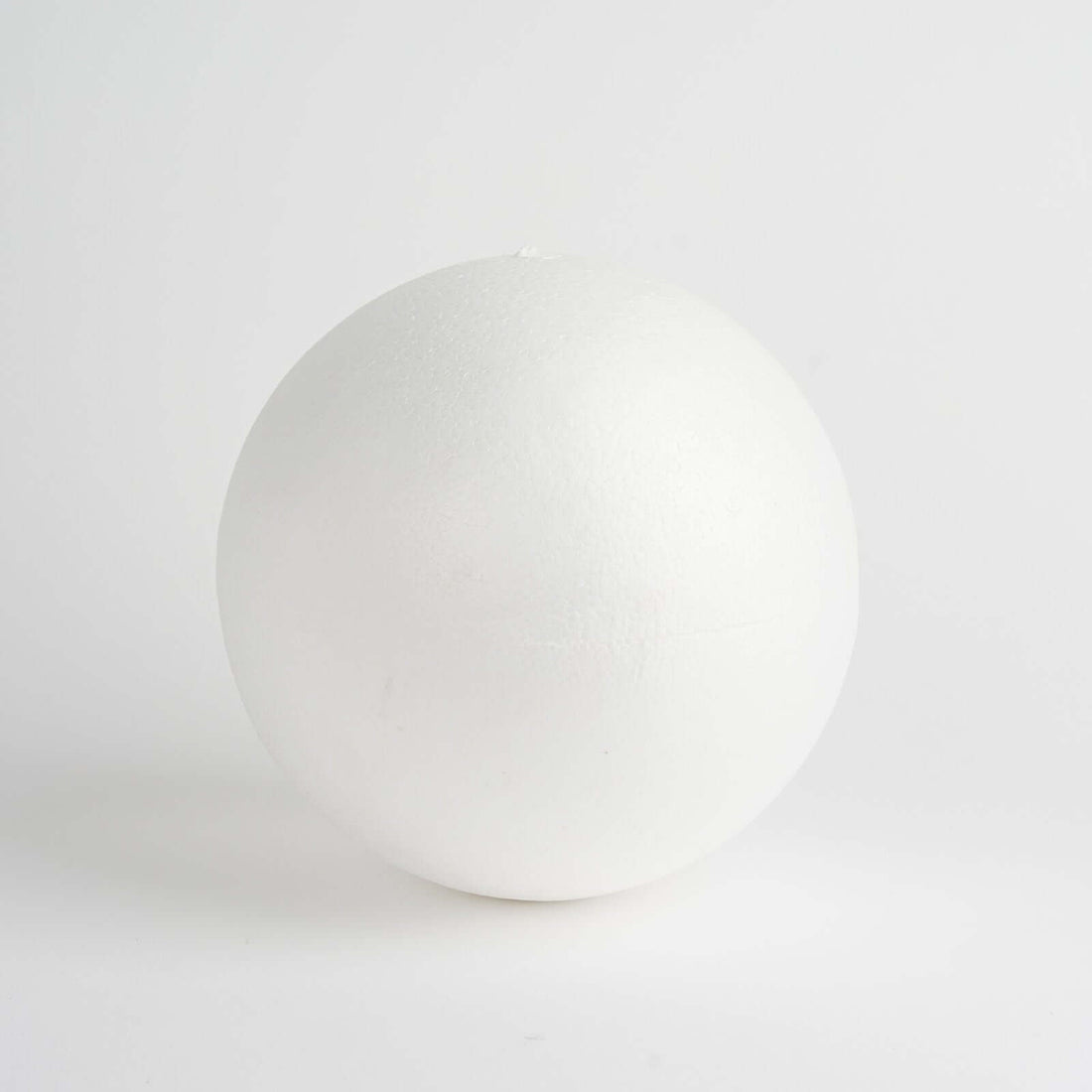 White spherical foam ball on a plain backdrop.