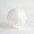 White spherical foam ball on a plain backdrop.