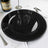 Black charger plate with beaded rim on a white table setting.