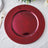 Burgundy decorative plate with beaded rim on a textured table setting.