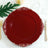 Elegant red decorative plate with gold accents on a table setting.
