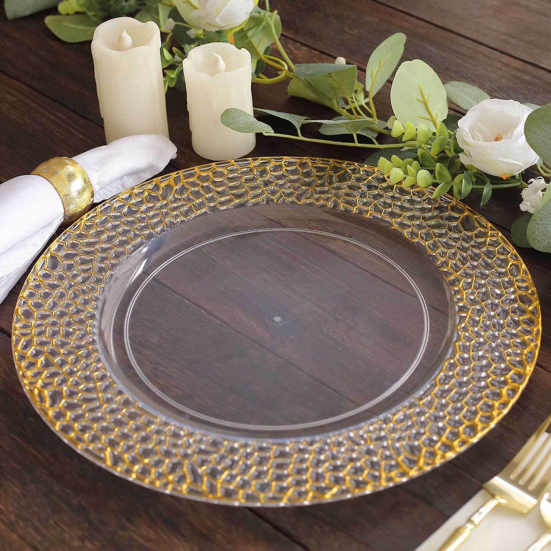 Clear charger plate with gold beaded rim, styled on a wooden table setting.