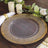 Clear charger plate with gold beaded rim, styled on a wooden table setting.