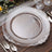 Elegant clear glass charger plate with ornate silver trim.