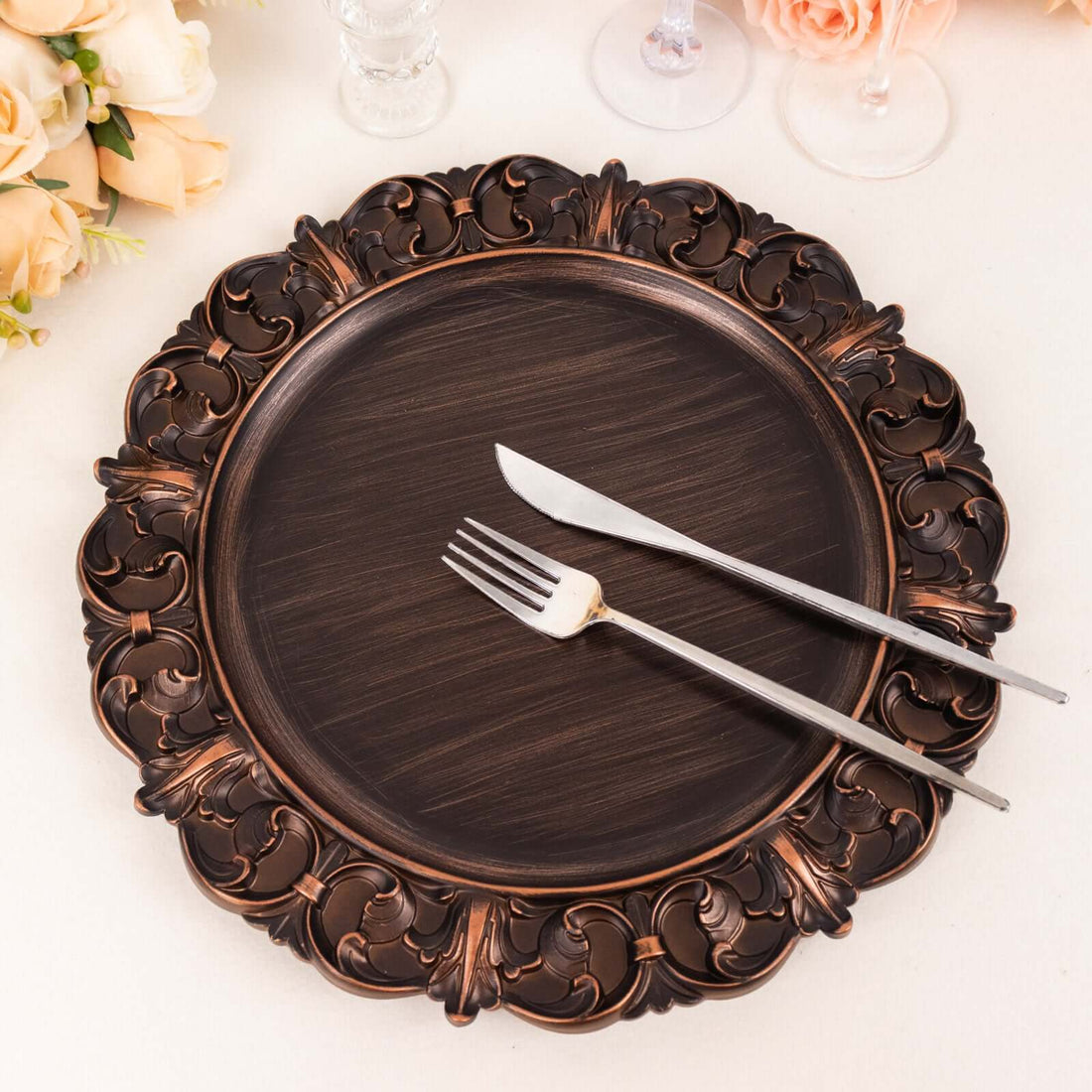 Elegant copper-accented charger plate with knife and fork setting.