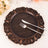 Elegant copper-accented charger plate with knife and fork setting.
