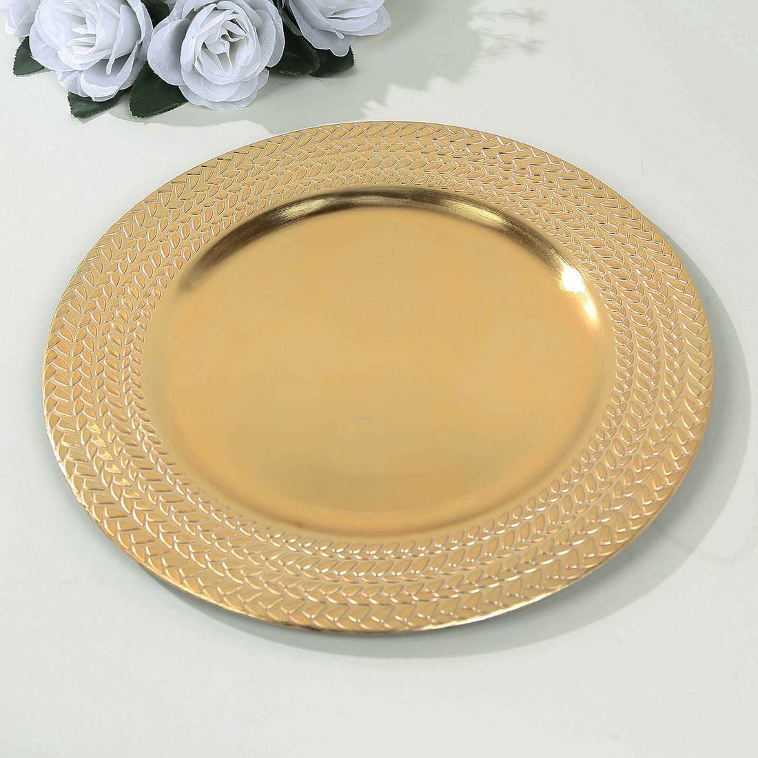 Gold decorative plate with intricate textured rim on a plain surface.