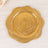 Gold decorative plate with a floral design on a light wooden surface.