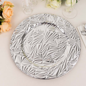 Silver decorative plate with geometric patterns on a table setting.