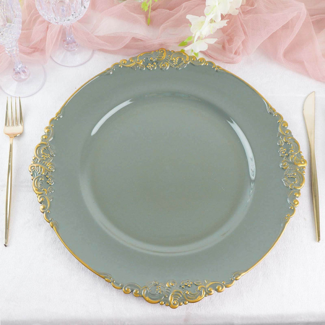 Elegant gray dinner plate with gold embellishments on a soft fabric backdrop.