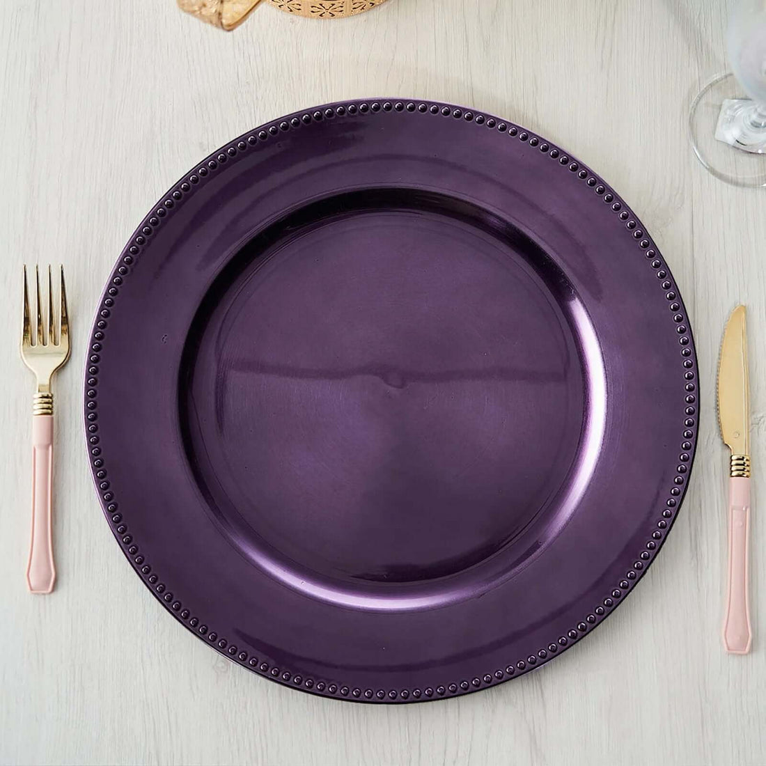 Purple decorative plate with beaded edge on a wooden table.