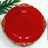 Red decorative plate with gold accents on a white background.