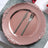 Rose gold decorative plate with a knife and fork on a table setting.