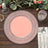 Decorative pink plate with intricate silver detailing on a wooden table setting.