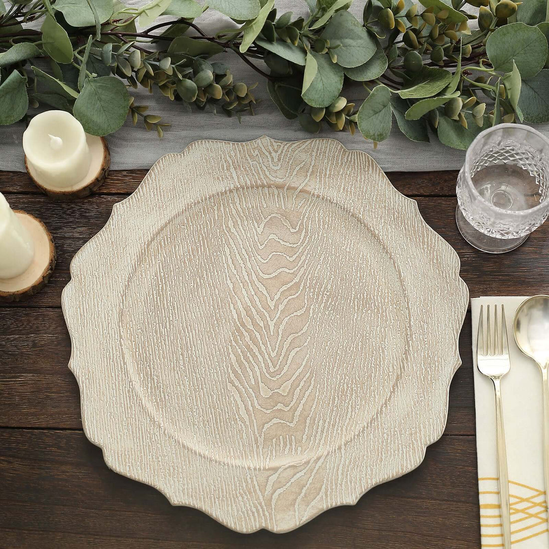 Textured wooden charger plate on a rustic table setting with greenery