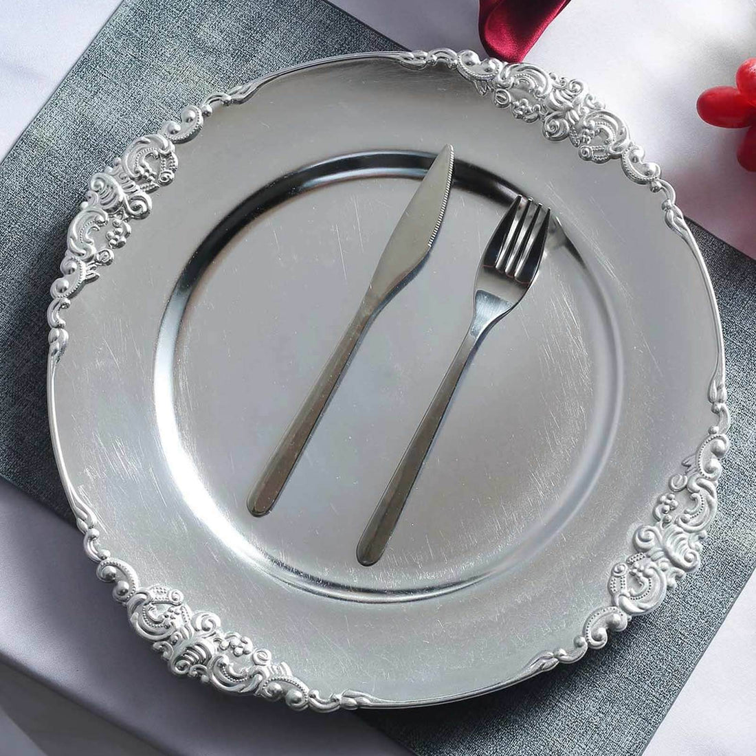 Elegant silver decorative plate with knife and fork arranged beautifully.