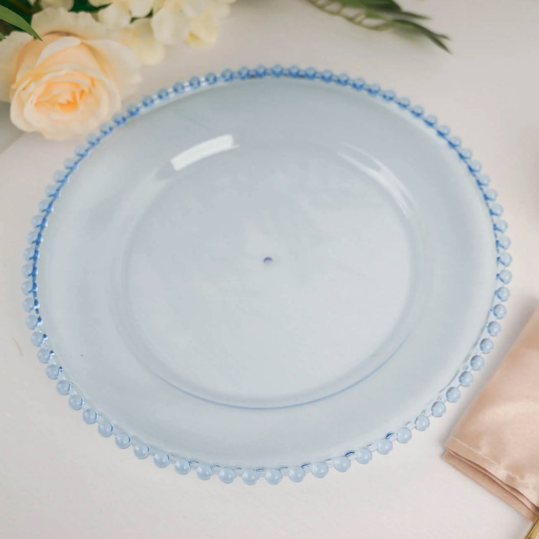 Elegant blue glass plate with beaded edge design.
