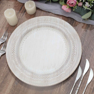Decorative white serving platter on a wooden table with candles and flowers.