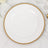 Elegant white plate with gold beaded rim on marble surface.
