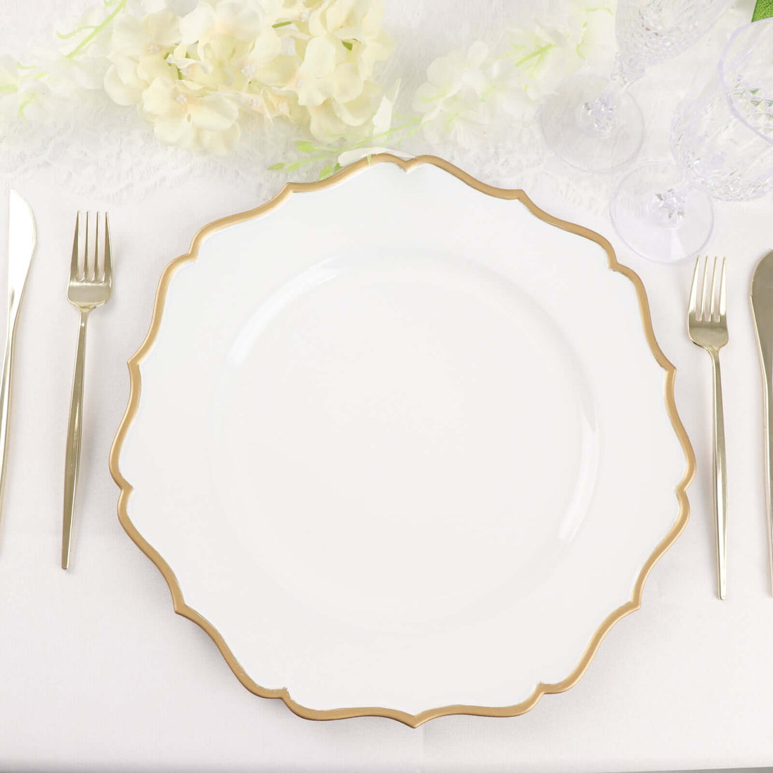 Elegant white plate with gold scalloped edge on a dining table setting.