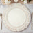 Ornate white decorative plate on a table setting with cutlery.
