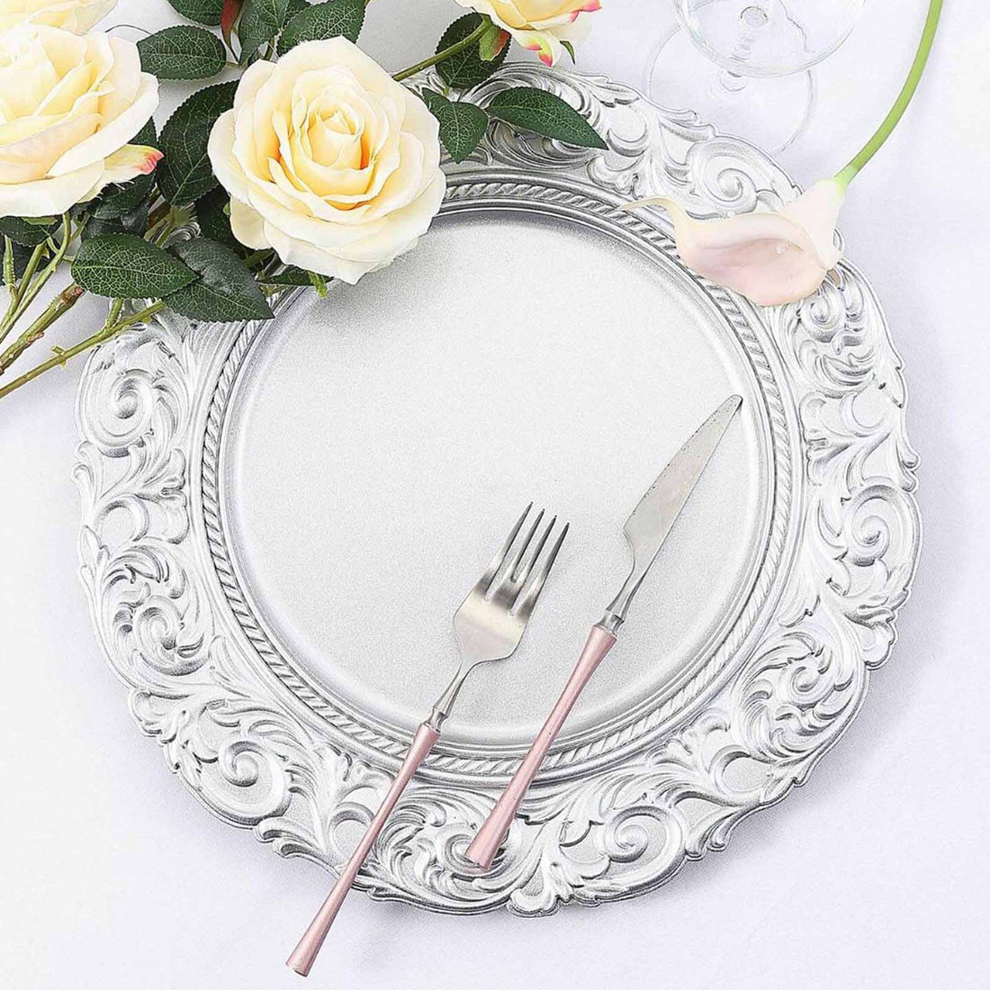 Elegantly styled silver plate with pink-handled fork and knife, adorned with roses.