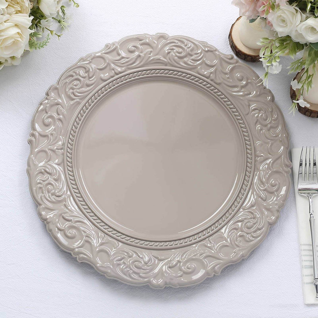 Decorative gray charger plate with intricate design on a white background.