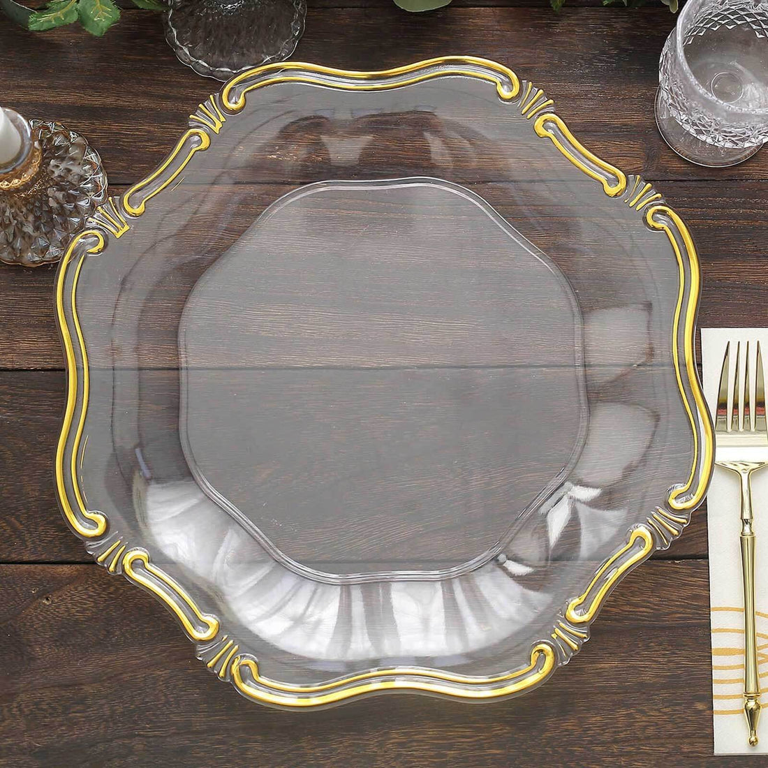 Elegant clear glass plate with gold trim on a wooden table.