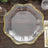 Elegant clear glass plate with gold trim on a wooden table.