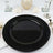 Black decorative plate on a dining table setting.