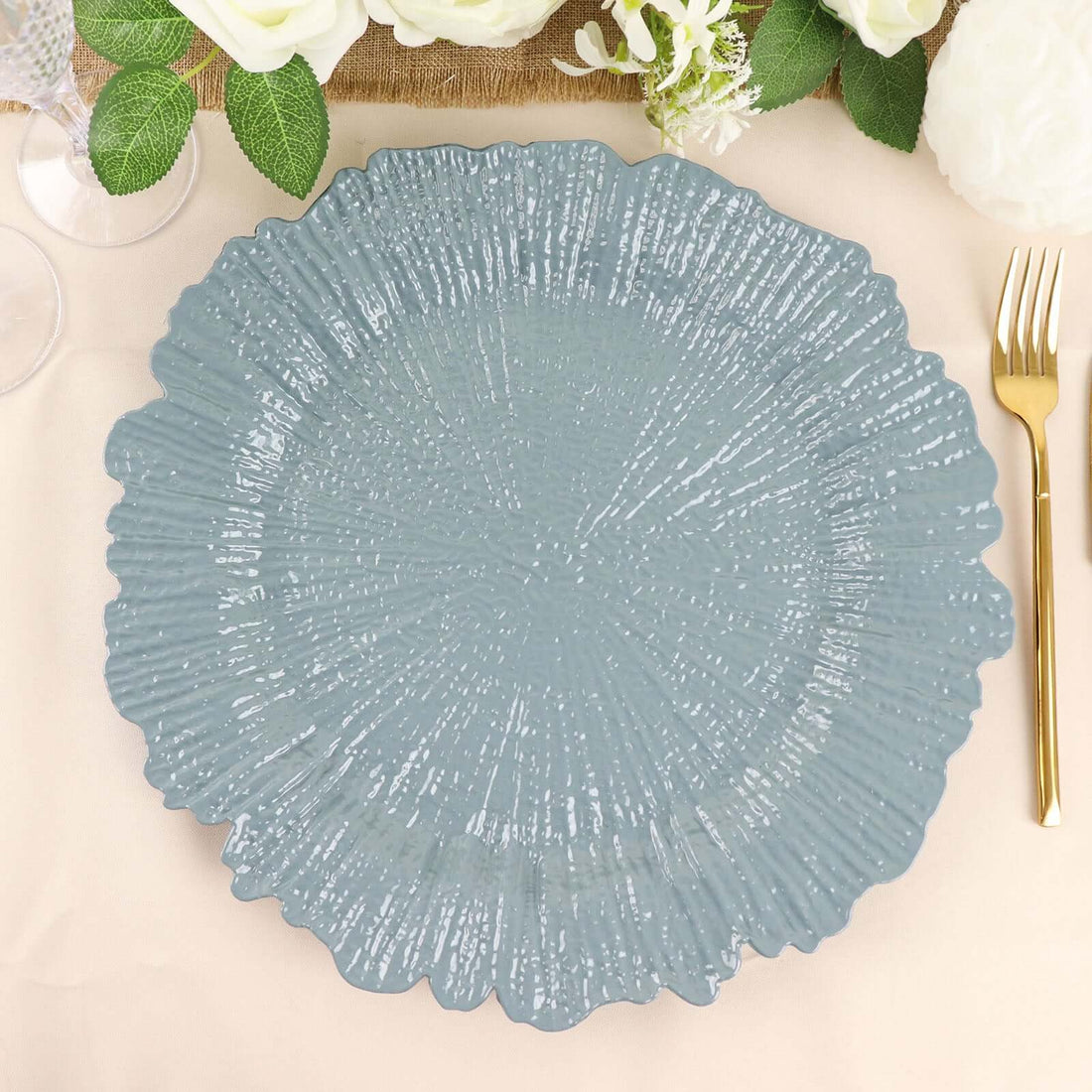 Decorative blue plate with textured design on a table setting.