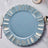 Blue decorative plate with gold accents on a marble table setting.