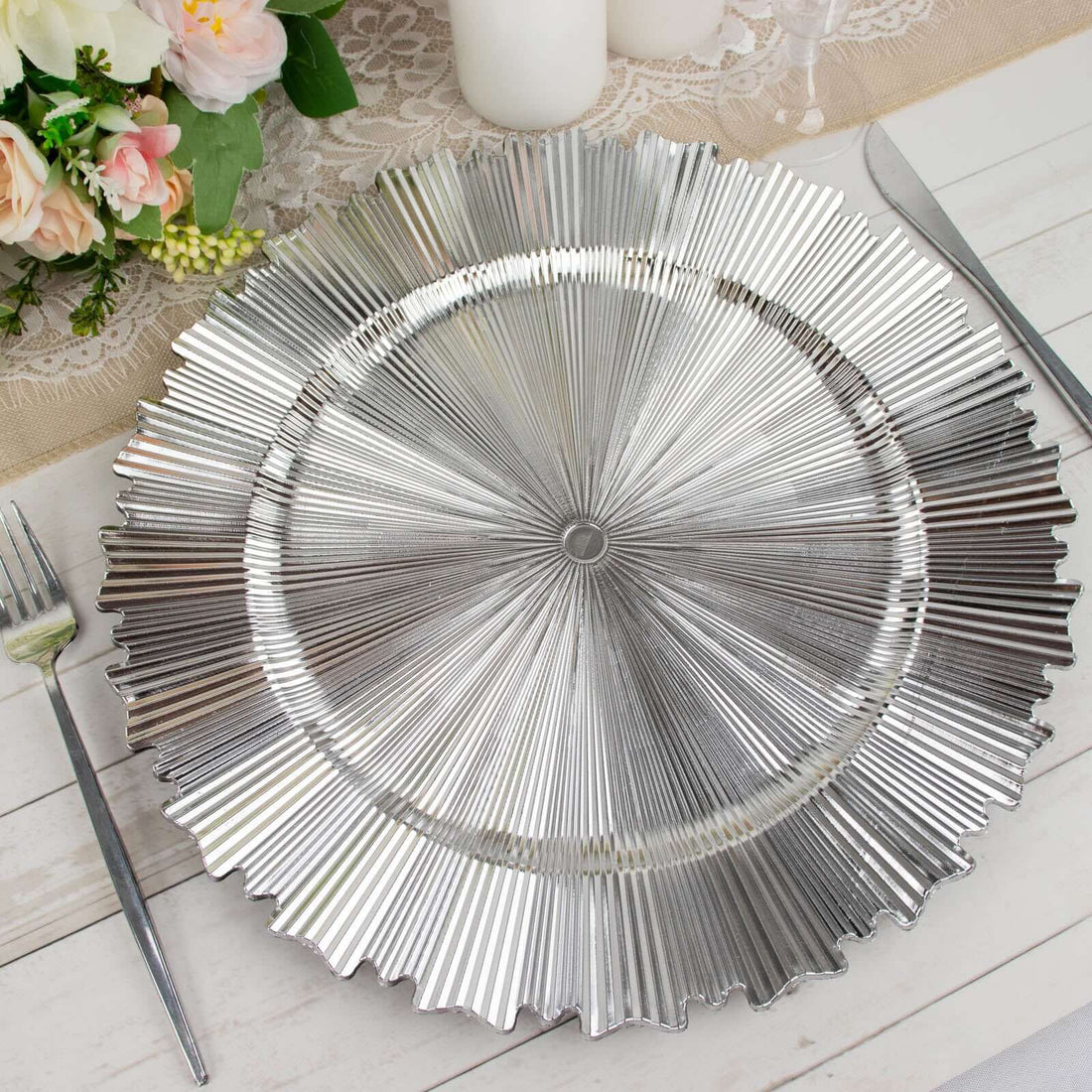 Silver charger plate with ridged design on a table setting.