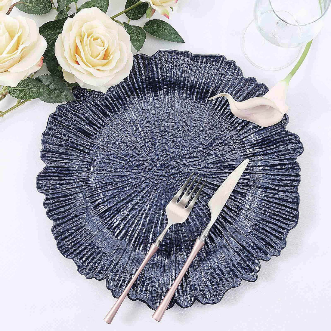 Navy blue decorative plate with floral design, fork, and knife.