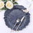 Navy blue decorative plate with floral design, fork, and knife.