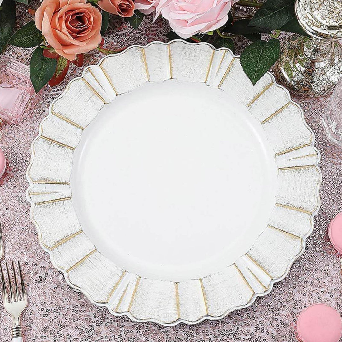 Elegant white plate with gold rim detail on a floral table setting.