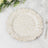 Textured white decorative plate with a scalloped edge on a marble surface.