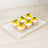 Cupcakes with mango topping and mint leaves on a decorative platter.