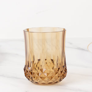 Amber geometric glass tumbler on a white background.