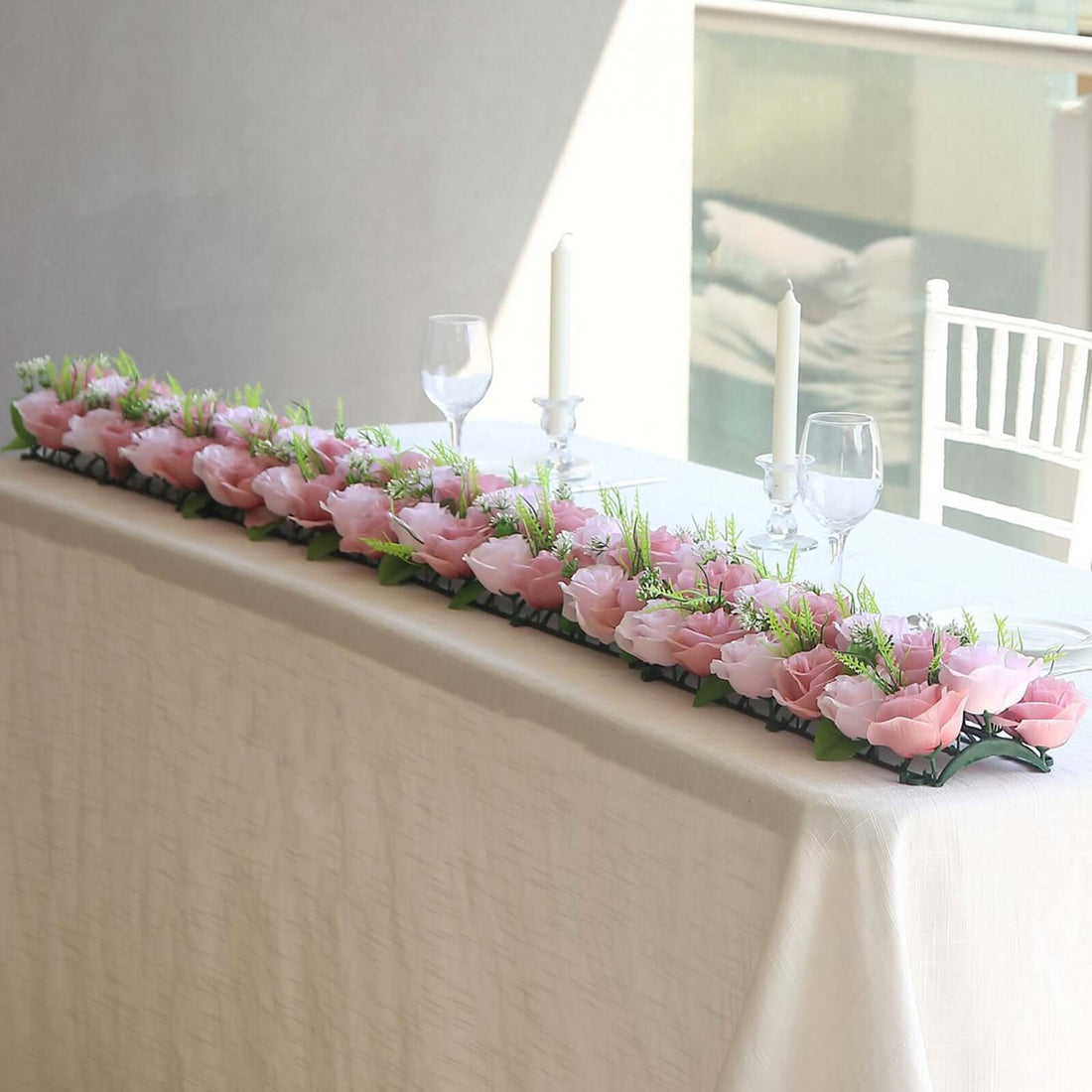 Elegant pink floral table runner with greenery for wedding decor.
