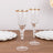 Elegant crystal champagne flutes with gold rim on a wooden table.