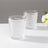 Set of two crystal glasses with gold rim on a plain background.
